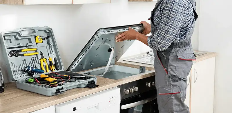 Handyman repairing a cooktop and checking wiring connections in Houston, TX