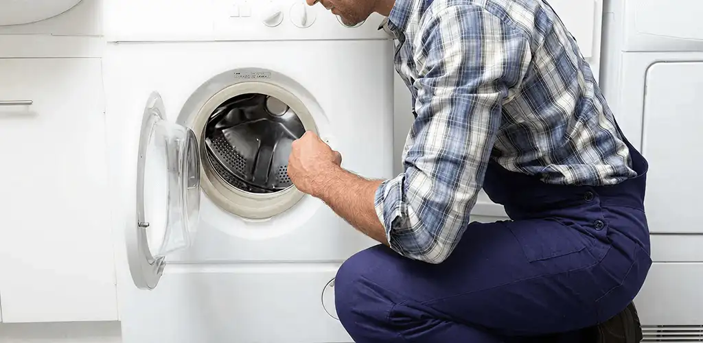 Handyman inspecting a dryer drum and internal parts for repair in Houston, TX