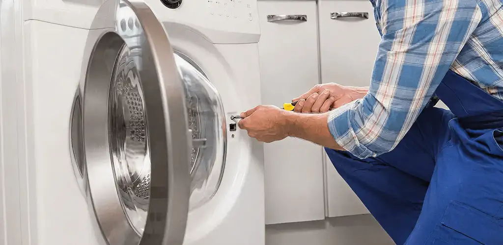 Handyman repairing a clothes dryer and checking electrical connections in Houston, TX