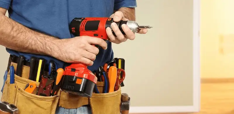 Handyman holding a power drill for home repairs and installations in Houston, TX